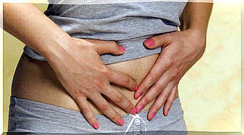 Woman with hands pressed to stomach