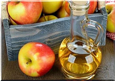 A bottle of apple cider vinegar and apples