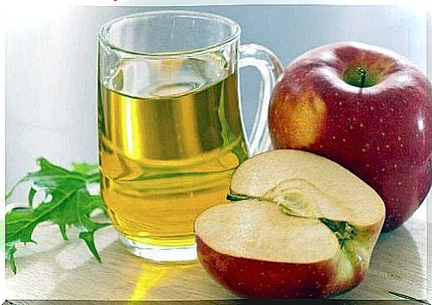 Glass of apple cider vinegar with apples