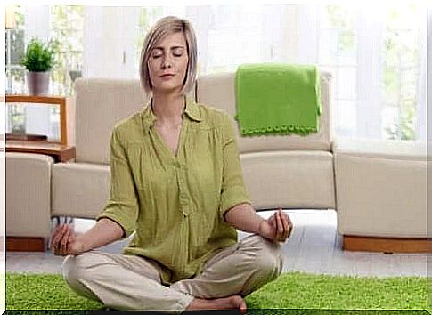 A woman is sitting in a meditation pose